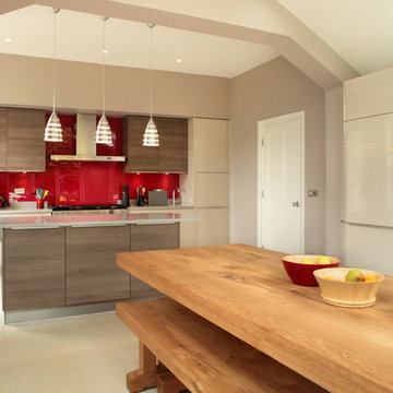 Contemporary open plan kitchen dining with red splashback