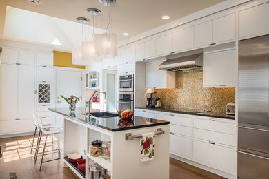 Open concept kitchen - mid-sized contemporary l-shaped medium tone wood floor open concept kitchen idea in Cleveland with an undermount sink, flat-panel cabinets, white cabinets, solid surface countertops, multicolored backsplash, mosaic tile backsplash, stainless steel appliances and an island