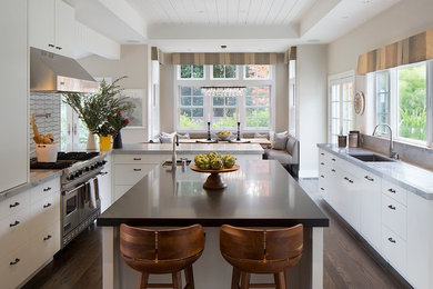 Inspiration for a large transitional galley dark wood floor and brown floor enclosed kitchen remodel in San Francisco with an undermount sink, flat-panel cabinets, white cabinets, white backsplash, porcelain backsplash, stainless steel appliances, an island, quartzite countertops and white countertops