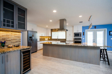 Exempel på ett modernt kök, med en undermonterad diskho, släta luckor, stänkskydd i glaskakel, rostfria vitvaror, klinkergolv i keramik och en köksö