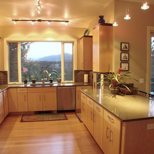This is an example of a large contemporary u-shaped open plan kitchen in Denver with an undermount sink, flat-panel cabinets, light wood cabinets, grey splashback, slate splashback, stainless steel appliances, light hardwood floors and with island.