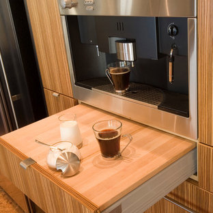 Diseño de cocina comedor en L, actual, grande, con fregadero bajoencimera, armarios con paneles lisos, puertas de armario de madera oscura, encimera de granito, electrodomésticos de acero inoxidable, suelo de corcho y una isla