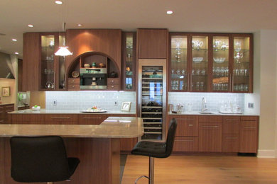 Photo of a contemporary l-shaped open plan kitchen in New Orleans with a submerged sink, flat-panel cabinets, medium wood cabinets, quartz worktops, grey splashback, glass tiled splashback, stainless steel appliances, ceramic flooring and a breakfast bar.