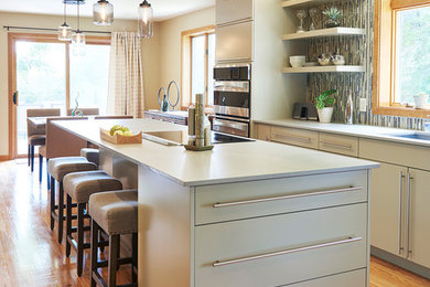 Example of a large trendy l-shaped eat-in kitchen design in Boston with flat-panel cabinets, green cabinets and an island