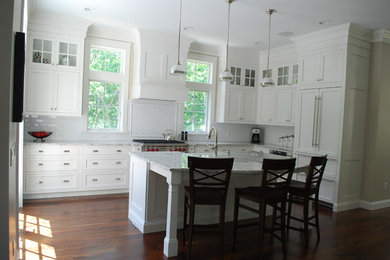 Large transitional l-shaped medium tone wood floor eat-in kitchen photo in Boston with shaker cabinets, white cabinets, granite countertops, white backsplash, subway tile backsplash, an island and a farmhouse sink