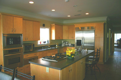 Example of a trendy l-shaped eat-in kitchen design in Other with an undermount sink, flat-panel cabinets, light wood cabinets, solid surface countertops and stainless steel appliances