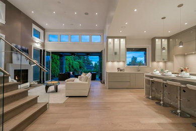 Inspiration for a contemporary l-shaped kitchen remodel in Vancouver with flat-panel cabinets, beige cabinets, quartz countertops, white backsplash, stone slab backsplash and an island