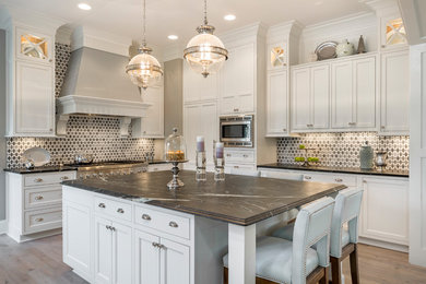 Inspiration for a timeless light wood floor and beige floor kitchen remodel in Cincinnati with beaded inset cabinets, white cabinets, multicolored backsplash, stainless steel appliances and an island