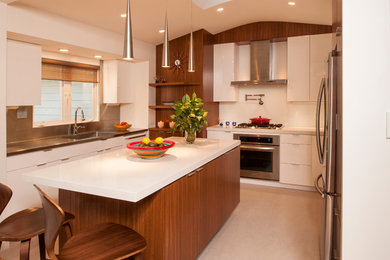 Photo of a contemporary u-shaped kitchen in DC Metro with an integrated sink, flat-panel cabinets, white cabinets, engineered stone countertops, white splashback, stainless steel appliances and an island.