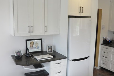 Example of a mid-sized trendy u-shaped dark wood floor eat-in kitchen design in Vancouver with shaker cabinets and white cabinets