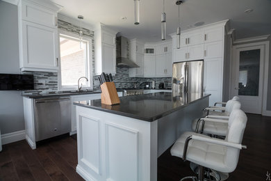 Eat-in kitchen - large contemporary l-shaped dark wood floor eat-in kitchen idea in Toronto with an undermount sink, recessed-panel cabinets, white cabinets, quartzite countertops, multicolored backsplash, glass tile backsplash, stainless steel appliances and an island