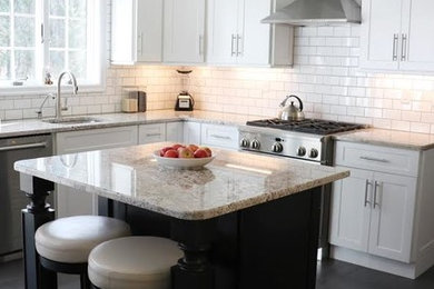 Exempel på ett mellanstort klassiskt kök, med en undermonterad diskho, skåp i shakerstil, vita skåp, granitbänkskiva, vitt stänkskydd, stänkskydd i tunnelbanekakel, rostfria vitvaror, klinkergolv i porslin, en köksö och svart golv