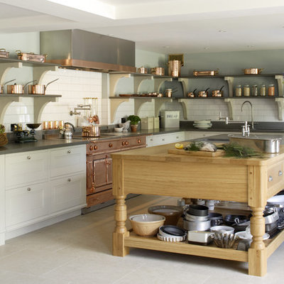 Example of a large transitional l-shaped limestone floor kitchen design in Hampshire with an island, white backsplash, subway tile backsplash, a drop-in sink, recessed-panel cabinets, wood countertops and colored appliances