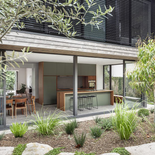 Inspiration for a mid-sized contemporary single-wall eat-in kitchen in Sydney with an undermount sink, green cabinets, wood benchtops, stainless steel appliances, concrete floors, with island, grey floor and brown benchtop.