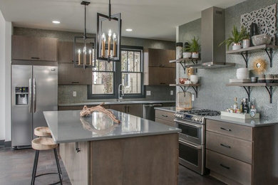 Example of a large trendy porcelain tile and brown floor kitchen design in Nashville with an undermount sink, flat-panel cabinets, quartz countertops, metallic backsplash, stainless steel appliances, an island, gray countertops, metal backsplash and dark wood cabinets