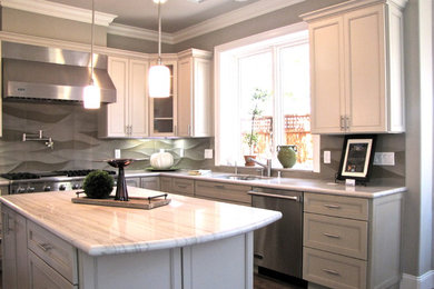 Example of a mid-sized trendy u-shaped medium tone wood floor and brown floor enclosed kitchen design in San Francisco with an undermount sink, recessed-panel cabinets, gray cabinets, granite countertops, gray backsplash, stainless steel appliances, an island and white countertops