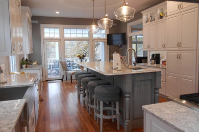 Idéer för att renovera ett mellanstort funkis grå grått kök, med en rustik diskho, luckor med upphöjd panel, vita skåp, granitbänkskiva, grått stänkskydd, stänkskydd i stickkakel, rostfria vitvaror, mellanmörkt trägolv, en köksö och brunt golv