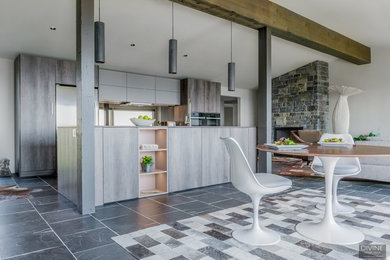 Large eclectic single-wall slate floor and gray floor open concept kitchen photo in Boston with an undermount sink, flat-panel cabinets, dark wood cabinets, granite countertops, metallic backsplash, glass sheet backsplash, stainless steel appliances, an island and brown countertops