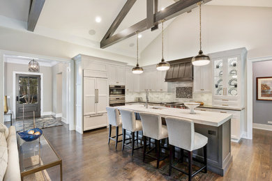 Example of a large transitional l-shaped dark wood floor and brown floor open concept kitchen design in Chicago with an undermount sink, recessed-panel cabinets, white cabinets, white backsplash, marble backsplash, paneled appliances and an island