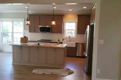 Huge arts and crafts galley dark wood floor eat-in kitchen photo in Wilmington with shaker cabinets, brown cabinets, granite countertops, white backsplash, an island and beige countertops