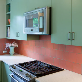 Inspiration for a small transitional u-shaped eat-in kitchen in Portland with an undermount sink, flat-panel cabinets, green cabinets, recycled glass benchtops, orange splashback, ceramic splashback, stainless steel appliances and light hardwood floors.