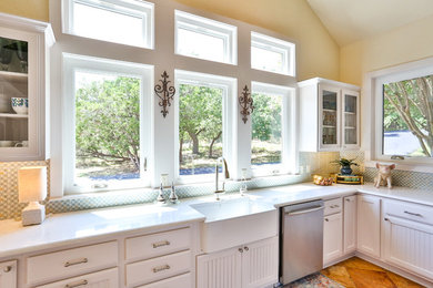 Example of a huge classic u-shaped eat-in kitchen design with recessed-panel cabinets, white cabinets, quartz countertops, blue backsplash, stone tile backsplash, stainless steel appliances and an island