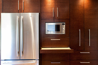 Eat-in kitchen - mid-sized modern u-shaped light wood floor and beige floor eat-in kitchen idea in Vancouver with a double-bowl sink, flat-panel cabinets, dark wood cabinets, quartzite countertops, gray backsplash, glass tile backsplash, stainless steel appliances and no island