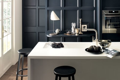Example of a trendy kitchen design in Other with an integrated sink, solid surface countertops and an island