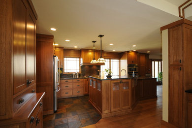 Example of a mid-sized arts and crafts l-shaped slate floor eat-in kitchen design in Chicago with shaker cabinets, medium tone wood cabinets, granite countertops, gray backsplash, matchstick tile backsplash, stainless steel appliances and an island