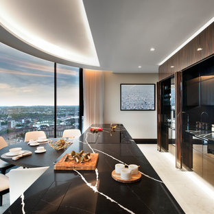 This is an example of a large contemporary single-wall enclosed kitchen in London with an integrated sink, recessed-panel cabinets, dark wood cabinets, marble worktops, black splashback, marble splashback, stainless steel appliances, marble flooring, an island, white floors and black worktops.