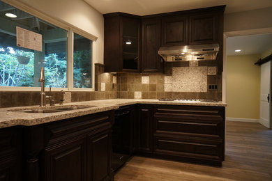 Example of a mid-sized transitional u-shaped medium tone wood floor and brown floor open concept kitchen design in Los Angeles with a double-bowl sink, quartz countertops, stainless steel appliances, a peninsula, raised-panel cabinets, dark wood cabinets, brown backsplash and slate backsplash