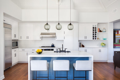 Inspiration for a mid-sized transitional l-shaped medium tone wood floor and brown floor open concept kitchen remodel in Los Angeles with an undermount sink, shaker cabinets, white cabinets, quartzite countertops, stainless steel appliances, an island and white backsplash