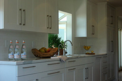 Example of a minimalist galley eat-in kitchen design in Orange County with an undermount sink, shaker cabinets, white cabinets, marble countertops, white backsplash, subway tile backsplash and stainless steel appliances