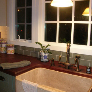 Photo of a mid-sized traditional l-shaped separate kitchen in San Diego with a farmhouse sink, shaker cabinets, green cabinets, wood benchtops, white splashback, ceramic splashback, stainless steel appliances, brick floors, with island and red floor.