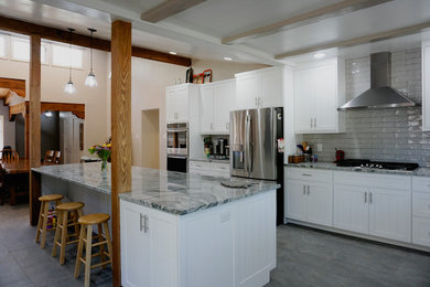 Inspiration for a mid-sized southwestern u-shaped ceramic tile and gray floor eat-in kitchen remodel in Albuquerque with a farmhouse sink, shaker cabinets, white cabinets, granite countertops, gray backsplash, ceramic backsplash, stainless steel appliances, an island and gray countertops