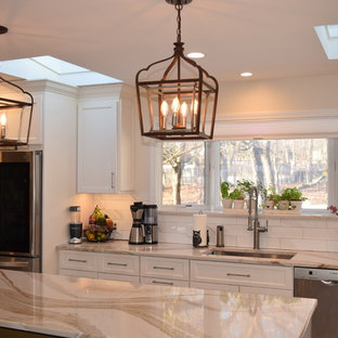 This is an example of a large contemporary l-shaped eat-in kitchen in New York with an undermount sink, shaker cabinets, yellow cabinets, quartz benchtops, white splashback, subway tile splashback, stainless steel appliances, porcelain floors, with island, white floor and yellow benchtop.