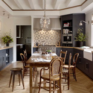 Diseño de cocina comedor en U, campestre, sin isla, con fregadero sobremueble, armarios estilo shaker, puertas de armario azules, salpicadero multicolor, electrodomésticos de acero inoxidable, suelo de madera clara y suelo beige