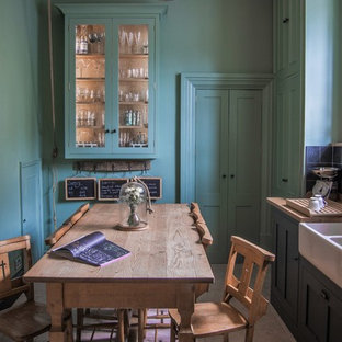Photo of a small country l-shaped kitchen/diner in Gloucestershire with shaker cabinets, green cabinets, wood worktops, limestone flooring, a built-in sink, black splashback, stone tiled splashback, coloured appliances and no island.