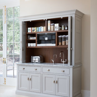 Cette photo montre une grand cuisine chic avec un placard à porte shaker, des portes de placard grises, une crédence marron, une crédence en fenêtre, un sol beige et un plan de travail gris.