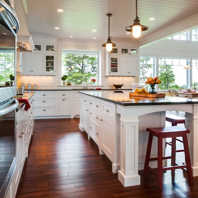 Eat-in kitchen - large craftsman u-shaped medium tone wood floor eat-in kitchen idea in Other with an undermount sink, shaker cabinets, white cabinets, granite countertops, white backsplash, ceramic backsplash, stainless steel appliances and an island