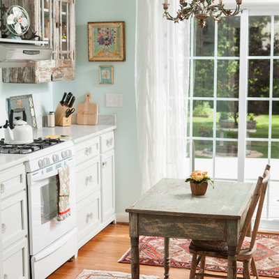 Inspiration for a shabby-chic style single-wall eat-in kitchen remodel in Wilmington with distressed cabinets, white appliances and shaker cabinets