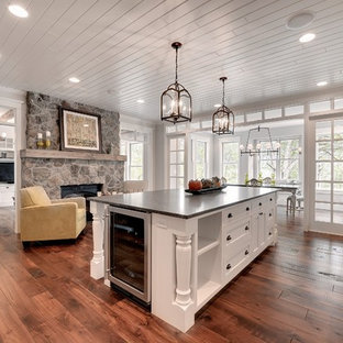 Large transitional enclosed kitchen appliance - Large transitional single-wall dark wood floor and brown floor enclosed kitchen photo in Minneapolis with a farmhouse sink, recessed-panel cabinets, white cabinets, stainless steel appliances, soapstone countertops and an island