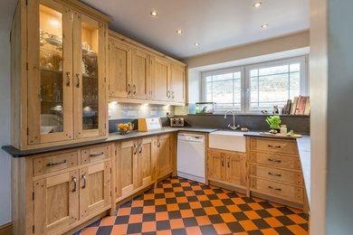 Photo of a small traditional galley kitchen/diner in Other with a belfast sink and orange floors.