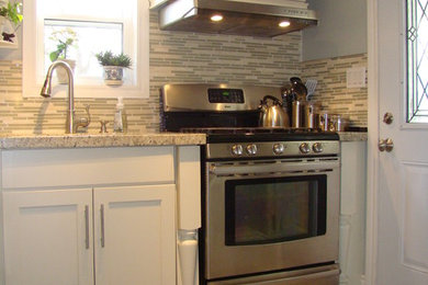 Example of a mid-sized minimalist l-shaped ceramic tile eat-in kitchen design in Toronto with an undermount sink, shaker cabinets, white cabinets, granite countertops, multicolored backsplash, matchstick tile backsplash and stainless steel appliances