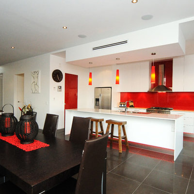 Inspiration for a contemporary galley open concept kitchen remodel in Brisbane with a double-bowl sink, flat-panel cabinets, white cabinets, red backsplash, glass sheet backsplash and stainless steel appliances