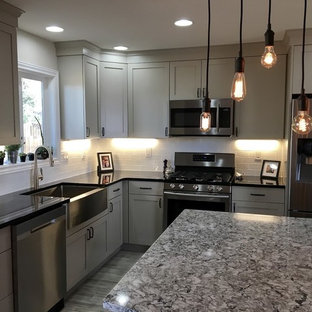 Inspiration for a mid-sized country l-shaped separate kitchen in Denver with a farmhouse sink, shaker cabinets, beige cabinets, quartz benchtops, white splashback, stainless steel appliances, vinyl floors, with island, subway tile splashback and grey floor.