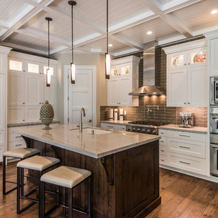 Mid-sized transitional enclosed kitchen designs - Example of a mid-sized transitional l-shaped medium tone wood floor and brown floor enclosed kitchen design in Salt Lake City with an undermount sink, shaker cabinets, white cabinets, stainless steel appliances, an island, granite countertops, gray backsplash and glass tile backsplash
