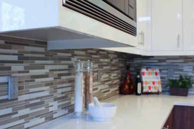 Mid-sized trendy l-shaped kitchen photo in Seattle with flat-panel cabinets, white cabinets, white backsplash, porcelain backsplash and an island