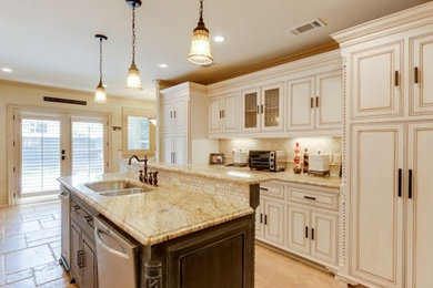 Inspiration for a mid-sized timeless galley ceramic tile and beige floor open concept kitchen remodel in Dallas with a double-bowl sink, raised-panel cabinets, white cabinets, granite countertops, beige backsplash, ceramic backsplash, stainless steel appliances and an island