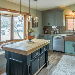 Design ideas for a small shabby-chic style l-shaped eat-in kitchen in Detroit with a farmhouse sink, shaker cabinets, green cabinets, quartz benchtops, grey splashback, glass tile splashback, stainless steel appliances, dark hardwood floors, with island, brown floor and beige benchtop.
